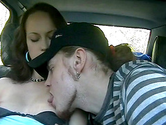 Teen brunette blows her boyfriend in the backseat of a car